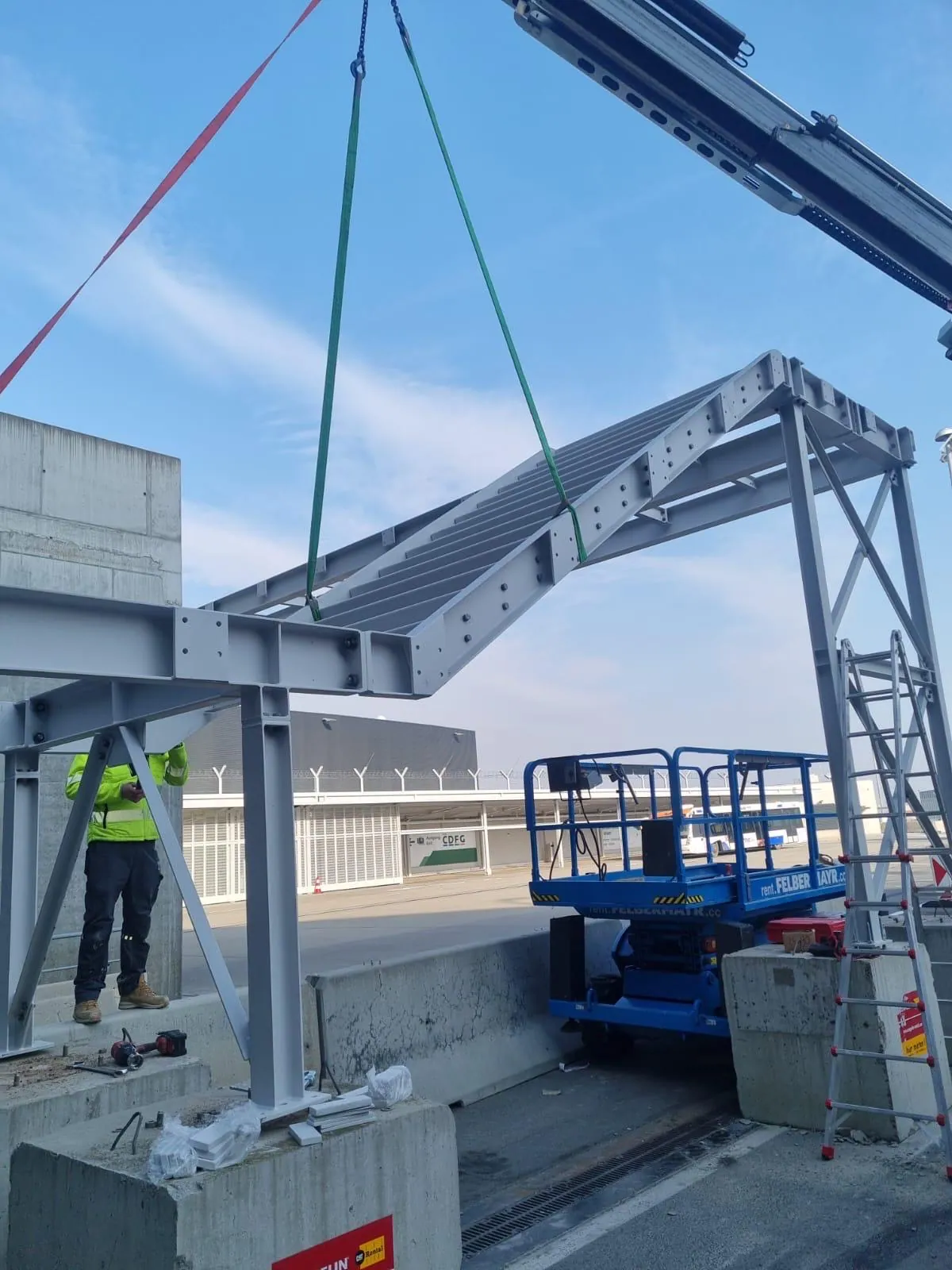 Stahlplattform hängt am Kran und wird auf einer Baustelle montiert