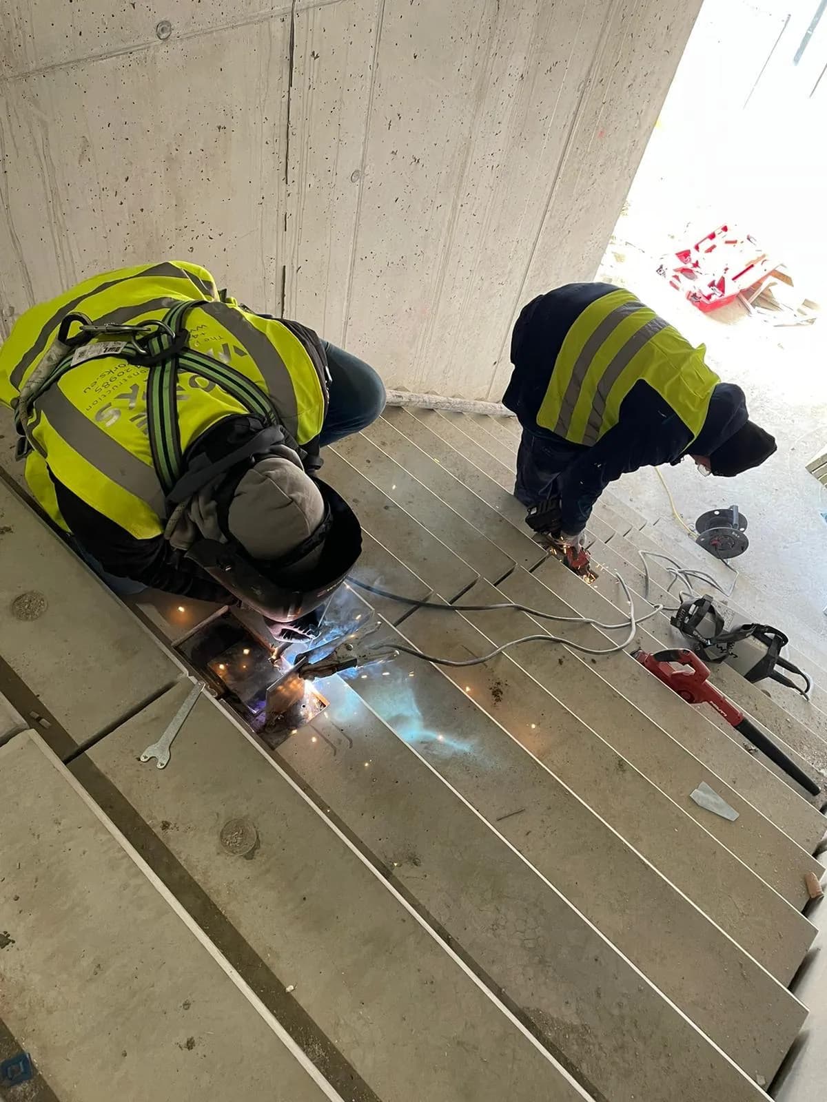 Zwei Schweißer bei Schweißarbeiten mit Funkenflug auf einer Stahlkonstruktion