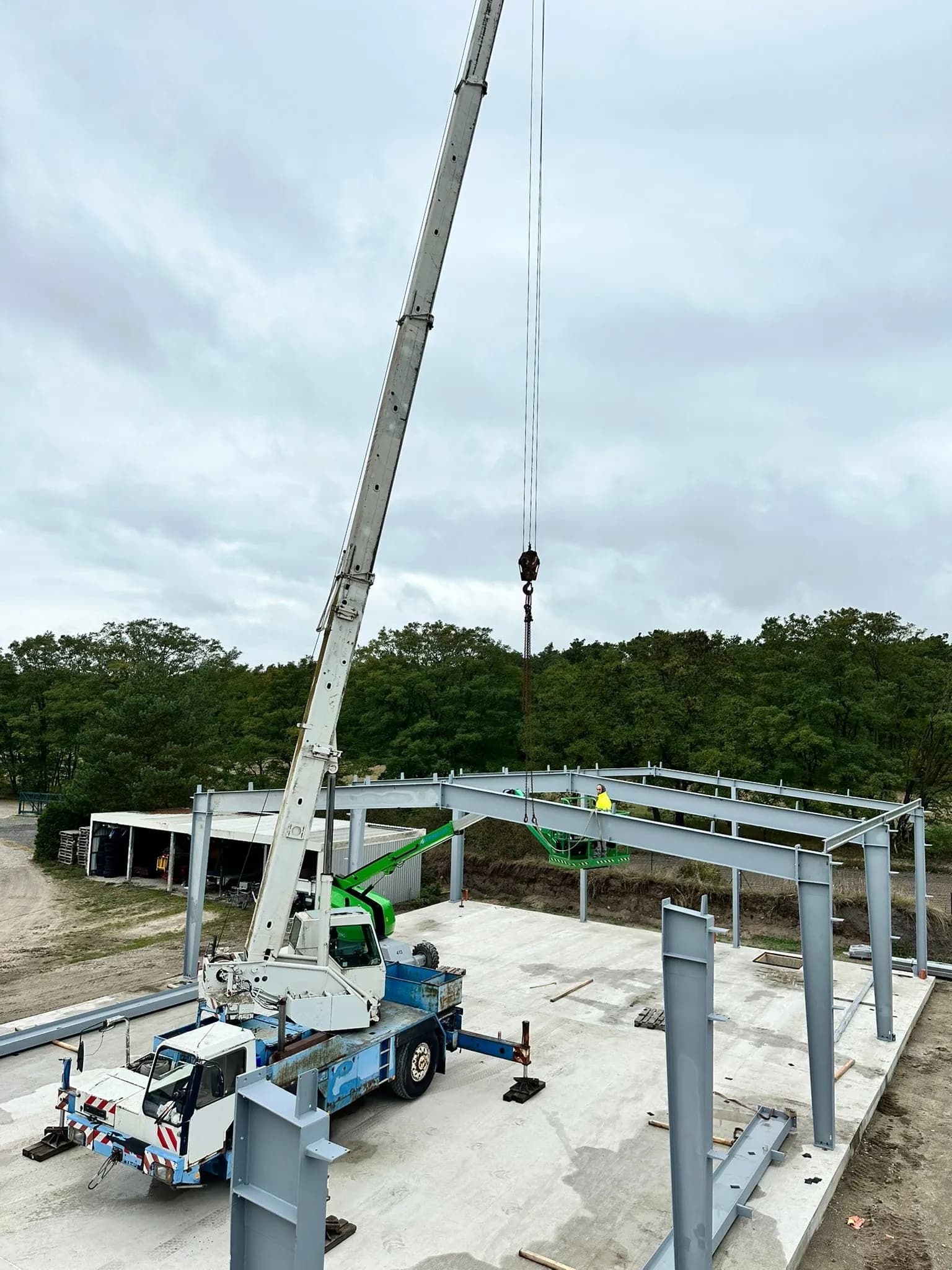 Autokran hebt einen Stahlrahmen auf einer Industriebaustelle